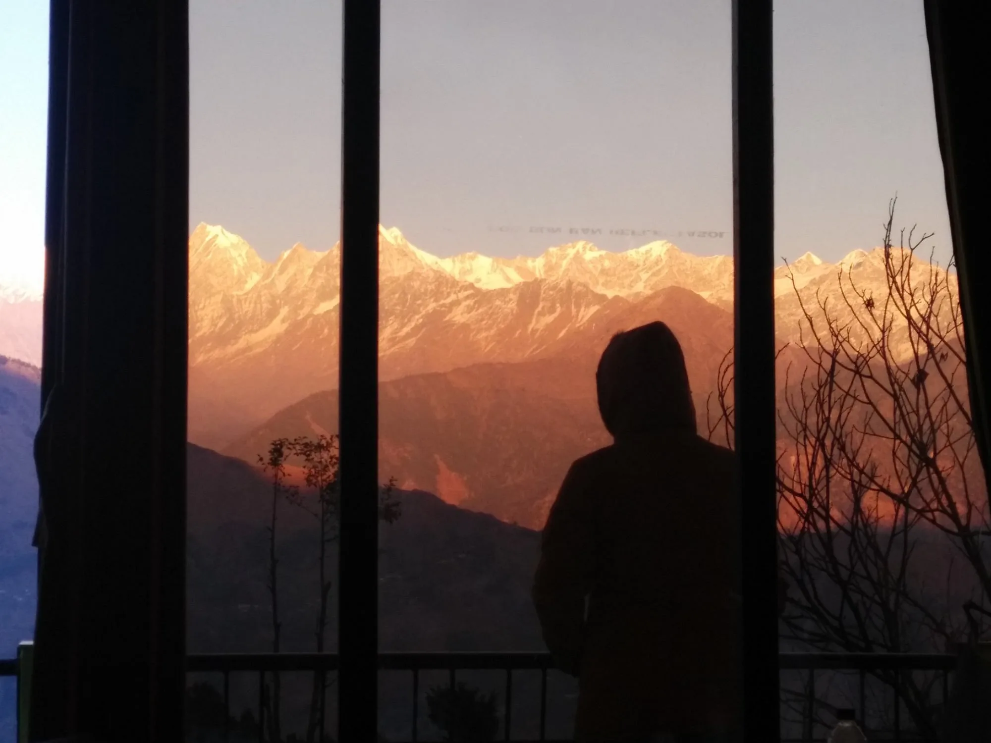Guest watching the sunrise over the Panchachuli peaks through a room window - TripAdvisor guest photo